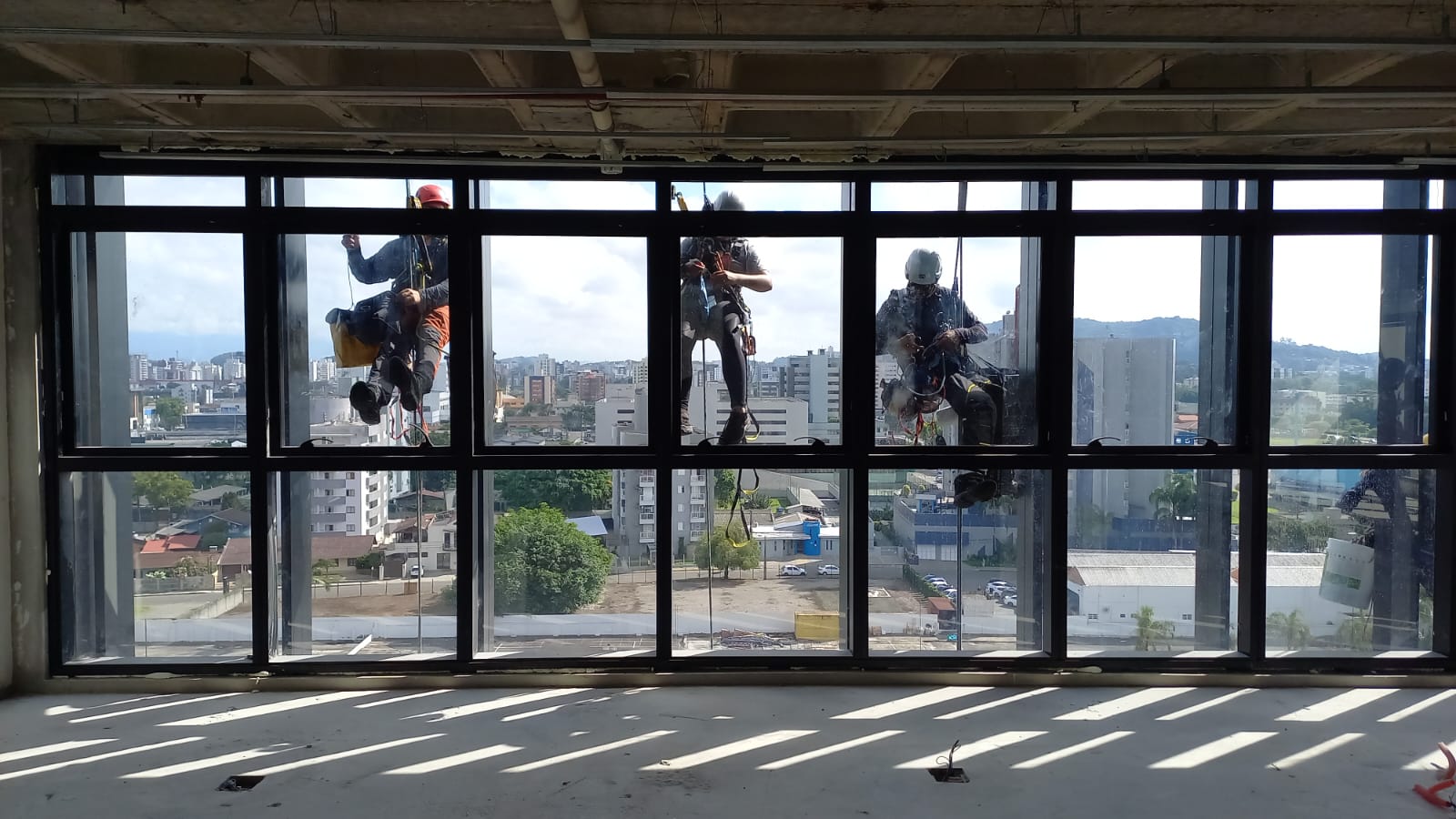 Equipe Capriche realizando limpeza de fachada em altura com técnica de rapel